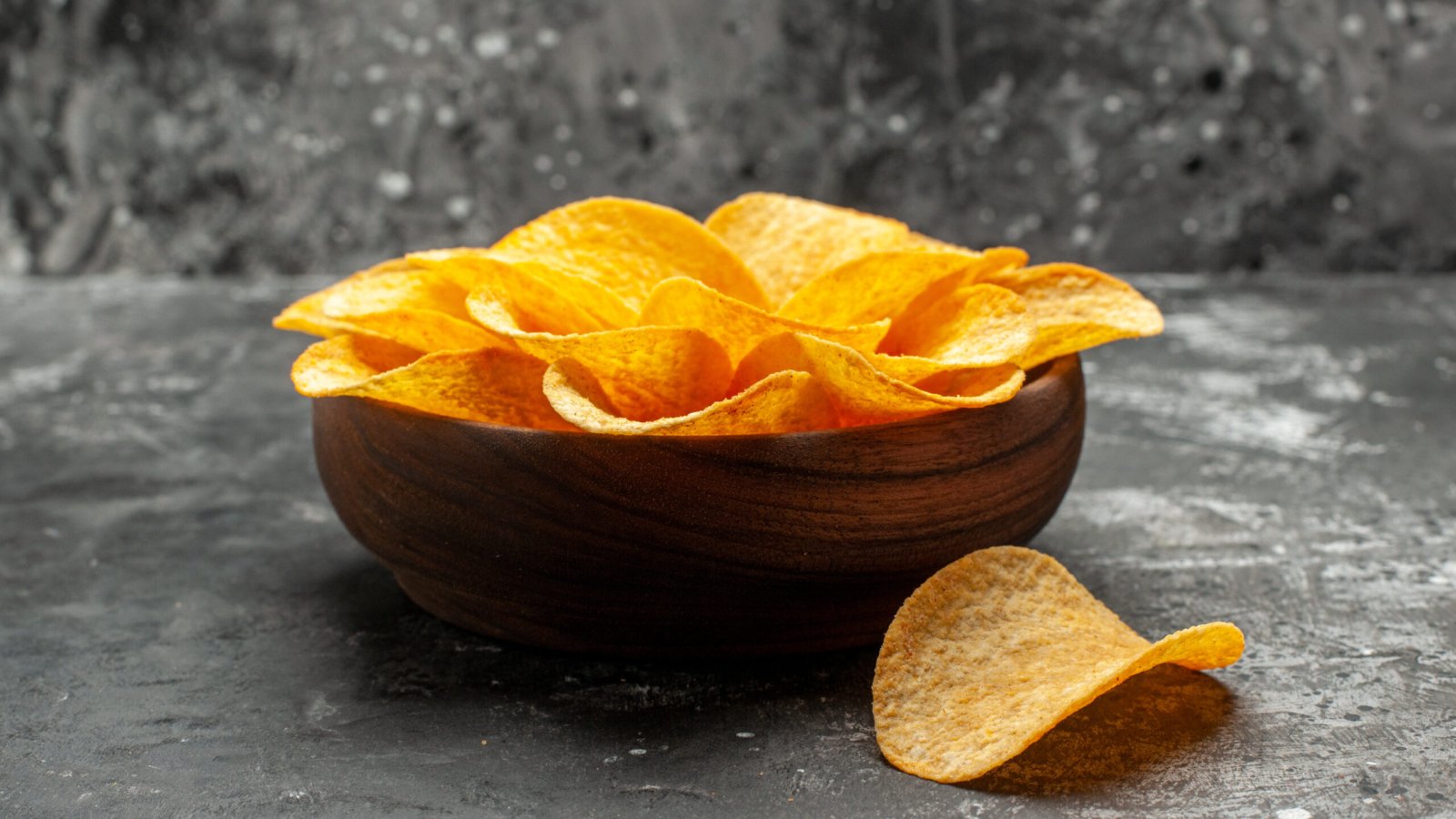 side-close-view-chips-bowl-dark-grey-table-with-dark-grey-background